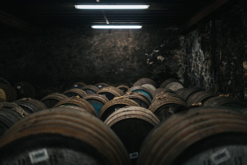Lifting a glass of whisky from a cask in the warehouse