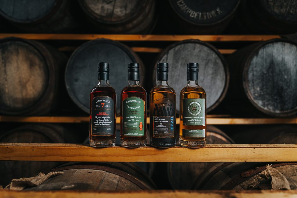 Cadenhead's bottles on a shelf above the casks